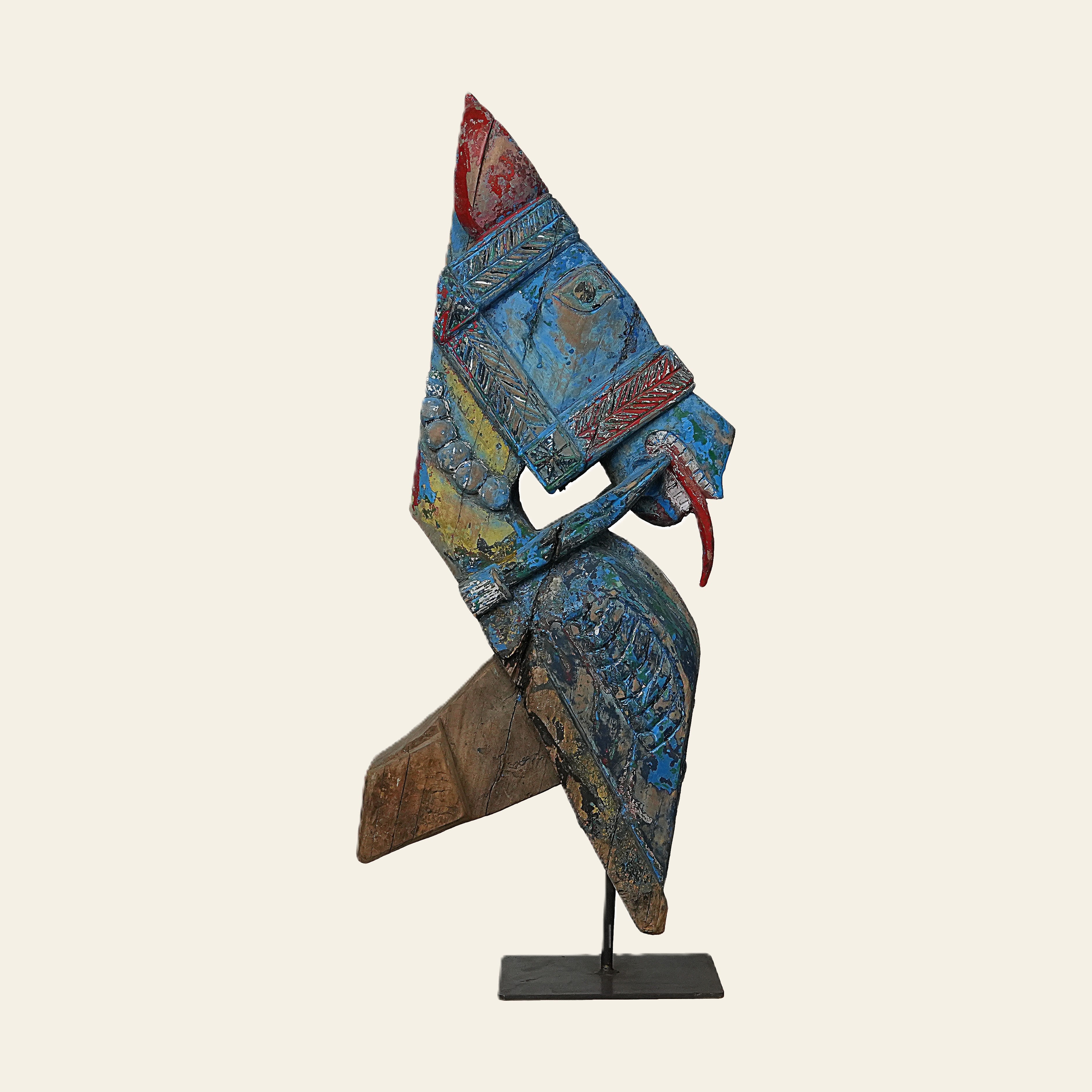 Colorful abstract sculpture on a stand against a beige background