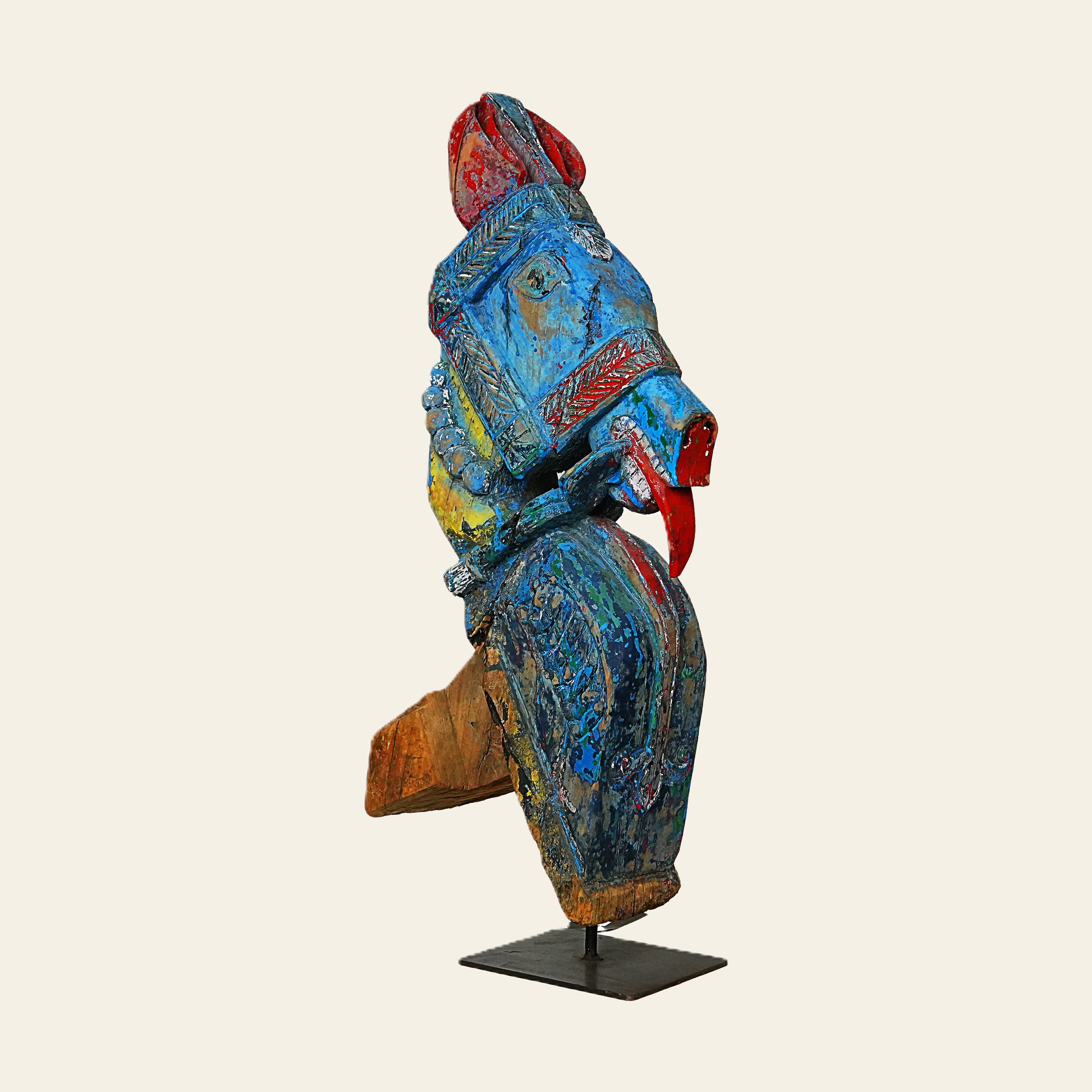 Colorful wooden horse sculpture on a stand against a beige background